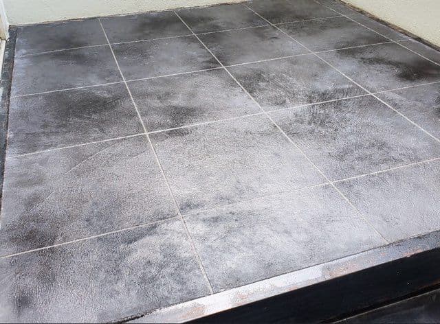 Black textured tiled flooring with a matte finish, ideal for modern indoor or outdoor spaces.