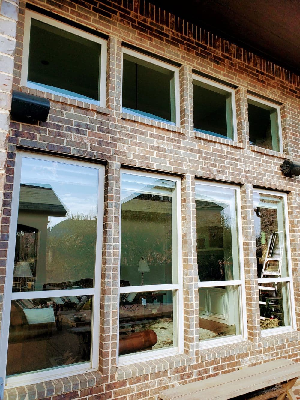 Modern brick house featuring large windows with natural light streaming in.