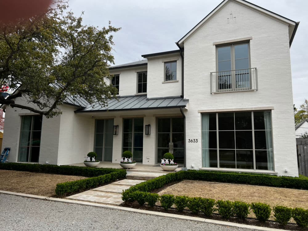 Modern white brick home with large windows and landscaped front garden at 3633.